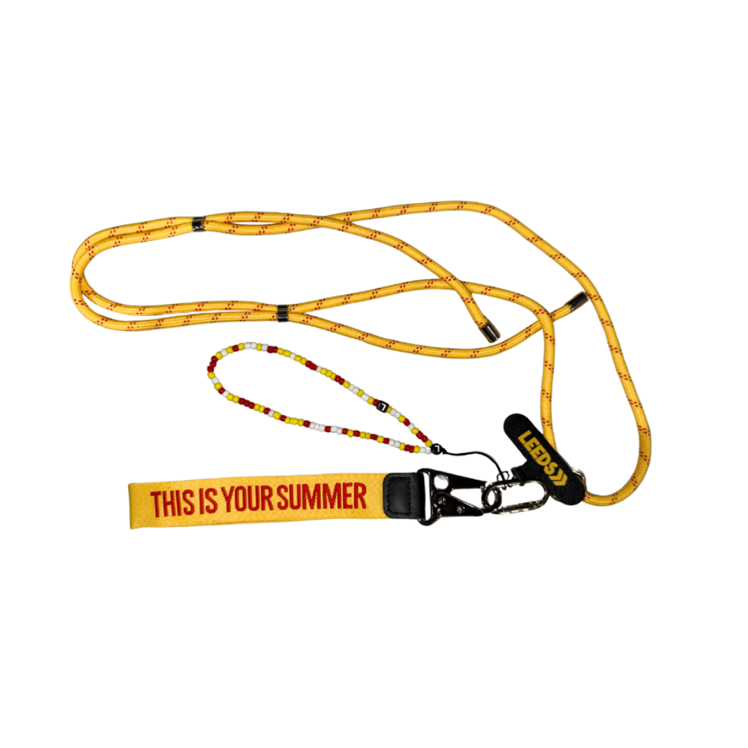 The Leeds 2025 Phone Lanyard by 2025 features a yellow rope with black accents, a beaded loop, clasp, and a fabric tag that says THIS IS YOUR SUMMER in bold red letters on yellow.