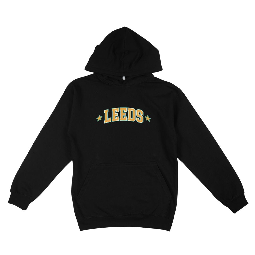 Stay cozy in the Leeds Festival 2026 Line-Up Black Hoodie from Reading & Leeds Festival. This black hoodie features a front pocket and showcases “LEEDS” in bold yellow letters outlined in green, flanked by a small yellow star on each side. Crafted from ultra-soft Ringspun Cotton for ultimate comfort, it boasts a classic unisex fit perfect for any festival fan.